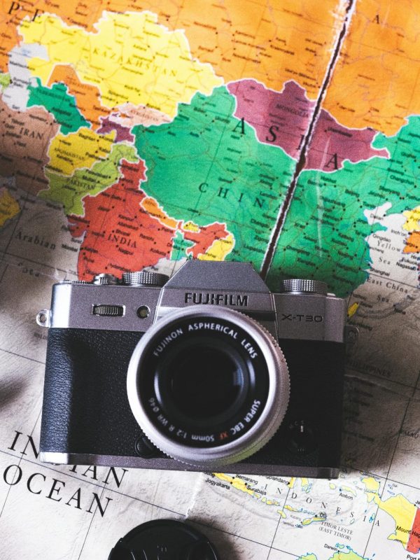 pexels-photo-9664007-9664007 Flat lay image featuring vintage cameras placed on a colorful world map, ideal for travel themes.
